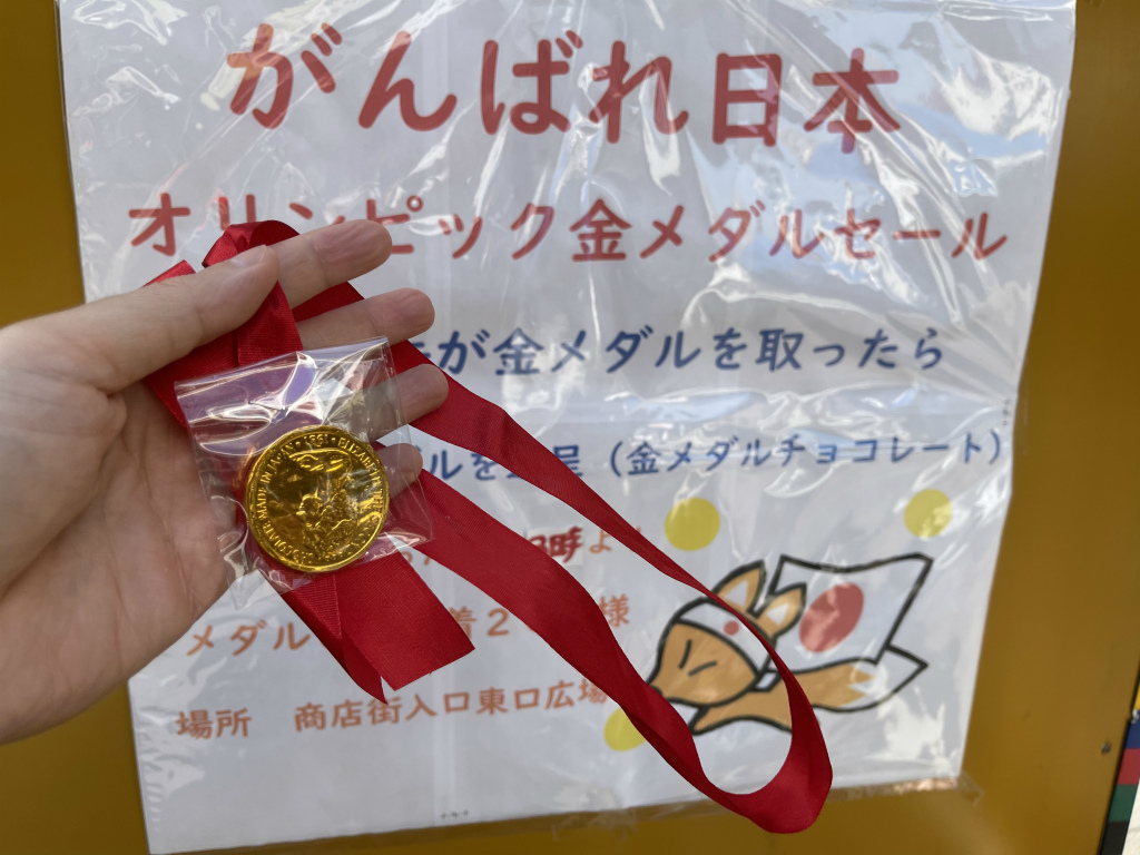 宮本町のイナリ通り商店街で日本が金メダル取った翌日に金メダルチョコ配ってる いたばしtimes